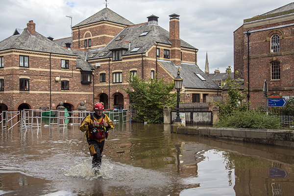 A rescue worker wading through a city street